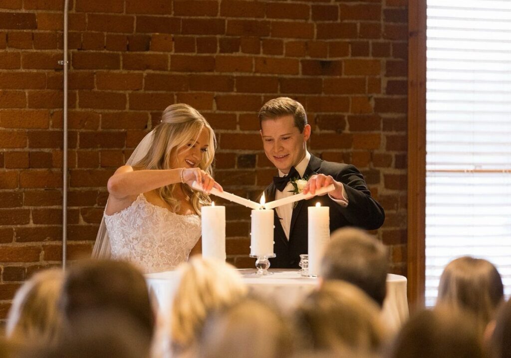Bride and groom lighting a unity candle during their wedding ceremony