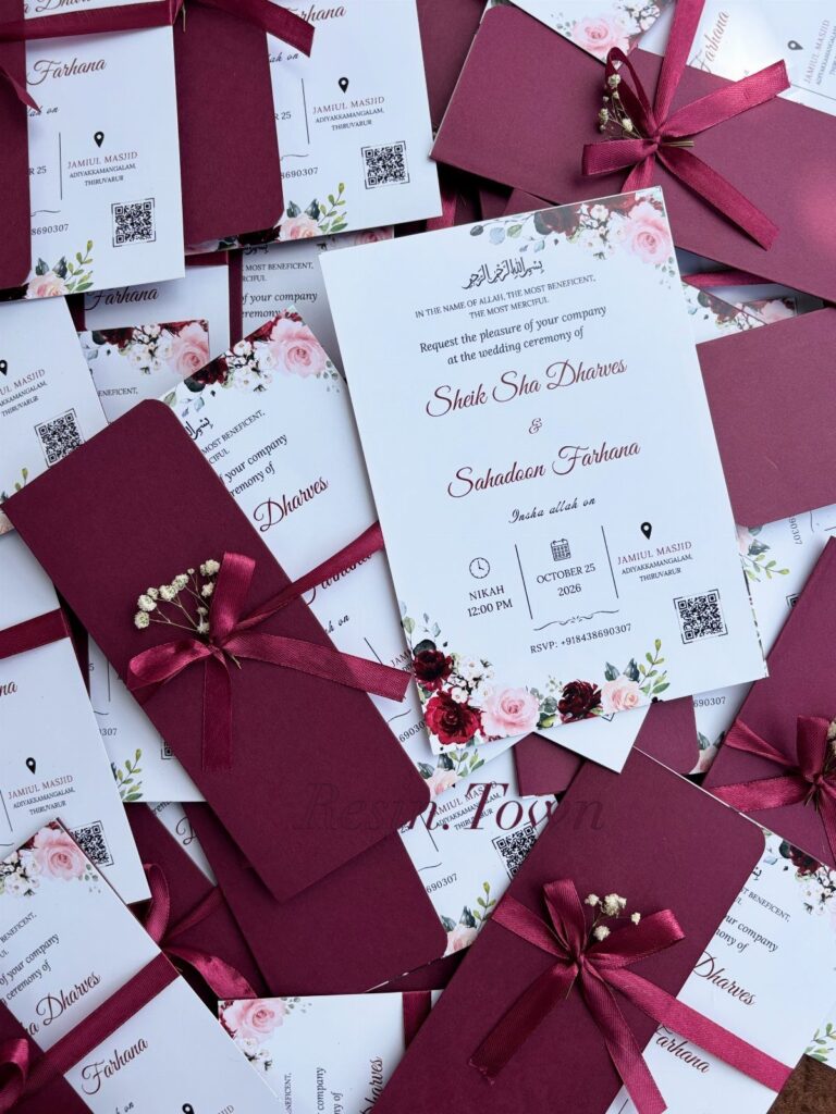 Wedding invitations with red floral designs and burgundy envelopes tied with ribbons.