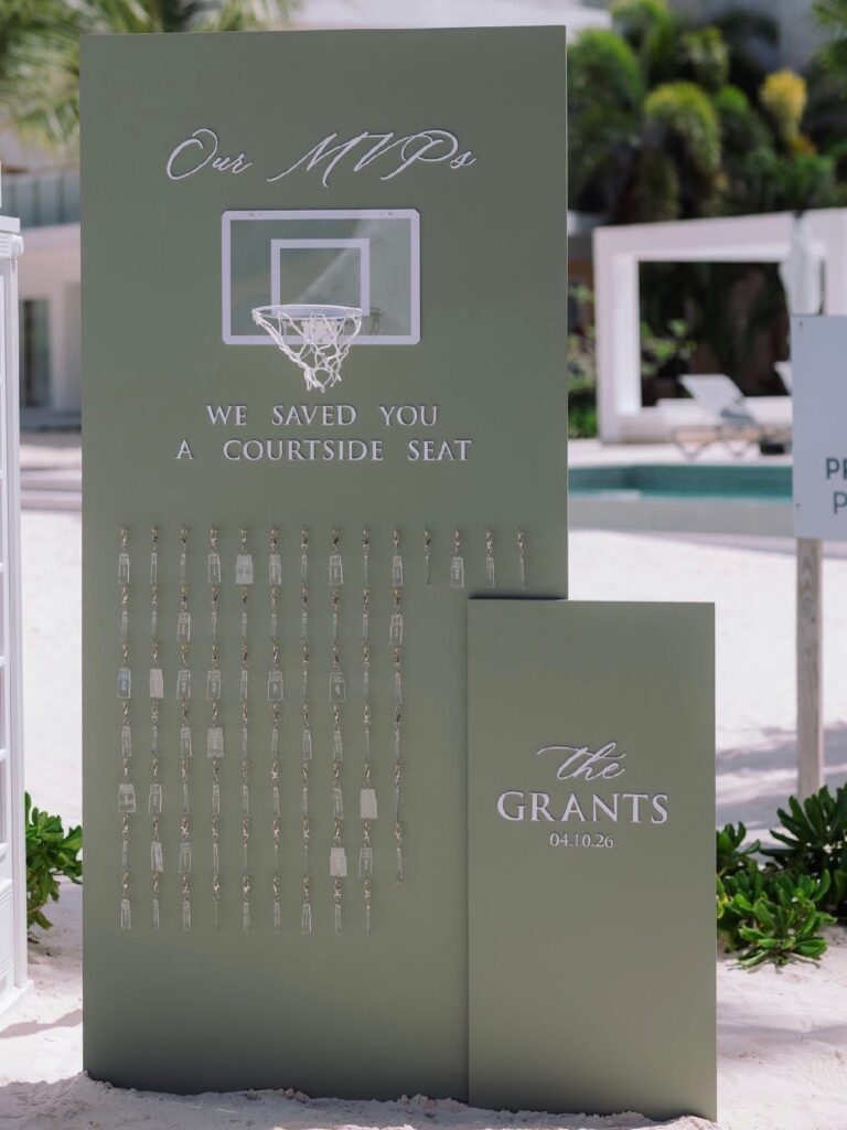 Sage green wedding seating chart with basketball theme and hanging guest name tags.