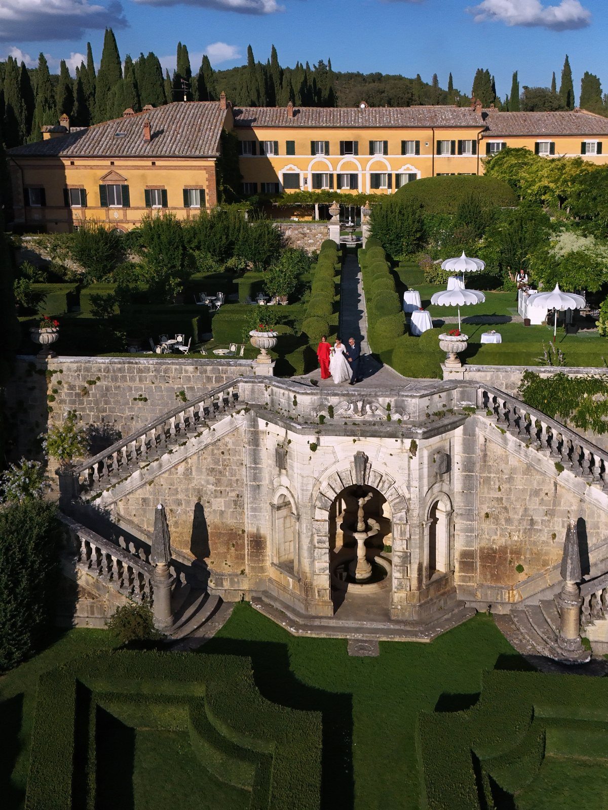 Wedding couple standing on a stone terrace of a Tuscan villa garden